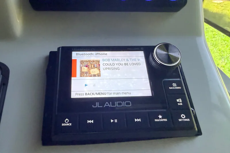Slide: The Image of ```json { "alt_text": "JL Audio system displaying song details, connected via Bluetooth to iPhone, in SCB S22, 2023." } ``` - 12