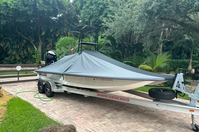 Slide: The Image of 2023 SCB S22 boat on trailer with cover, parked in a lush garden setting. - 5