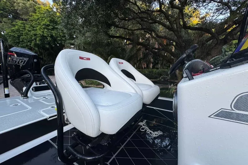 Slide: The Image of 2023 SCB S22 boat interior with white seats and steering wheel, surrounded by lush greenery. - 2