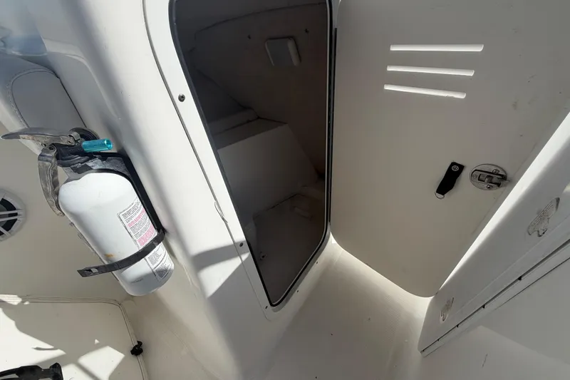 Slide: The Image of 2008 Sea Fox 216 Dual Console interior with open storage compartment and mounted fire extinguisher. - 30