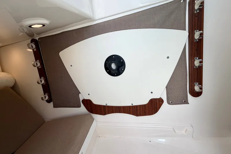 Slide: The Image of Interior view of a 2017 Pursuit DC 325 Dual Console boat, featuring rod holders and seating. - 33