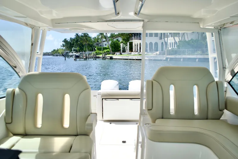 Slide: The Image of 2017 Pursuit DC 325 Dual Console boat interior with waterfront view. - 17