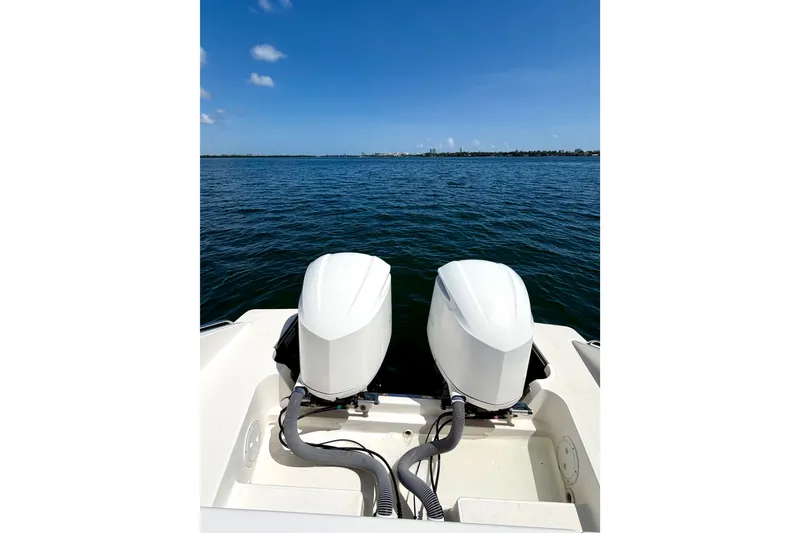 Slide: The Image of 2017 Pursuit DC 325 Dual Console boat with twin outboard motors on open water. - 27