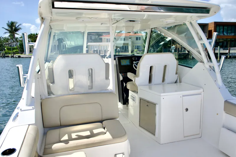 Slide: The Image of 2017 Pursuit DC 325 Dual Console boat interior with seating and helm, dockside view. - 22