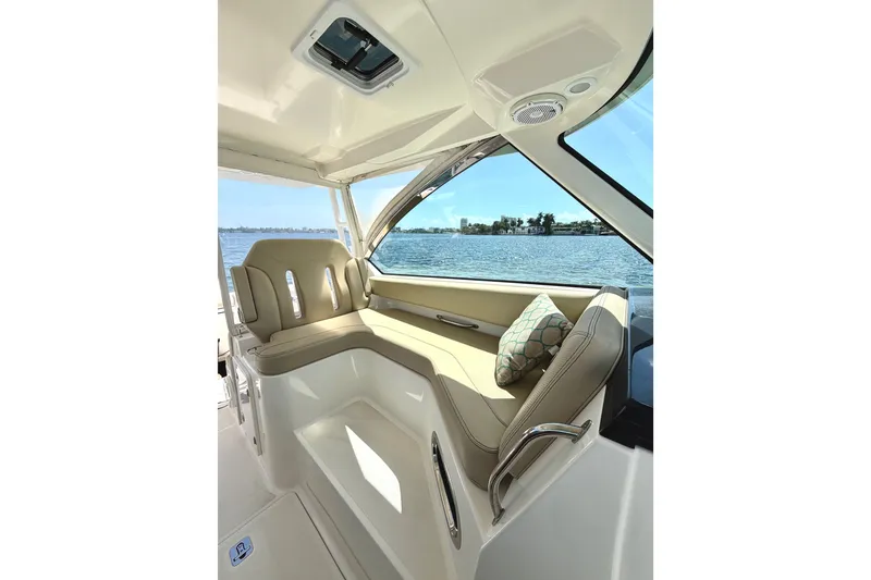 Slide: The Image of 2017 Pursuit DC 325 Dual Console interior with beige seating and scenic water view. - 31