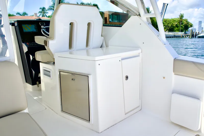 Slide: The Image of 2017 Pursuit DC 325 Dual Console interior with helm seat and storage cabinet. - 21