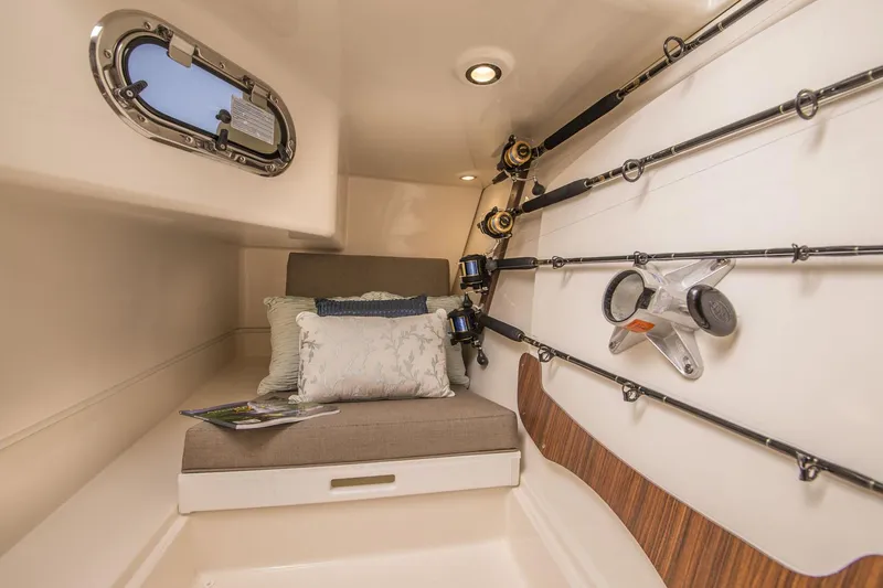 Slide: The Image of Manufacturer Provided Image: 2017 Pursuit DC 325 Dual Console cabin with fishing rod storage and cushioned seating. - 34