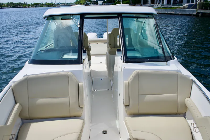 Slide: The Image of 2017 Pursuit DC 325 Dual Console boat with beige seating on calm water. - 14