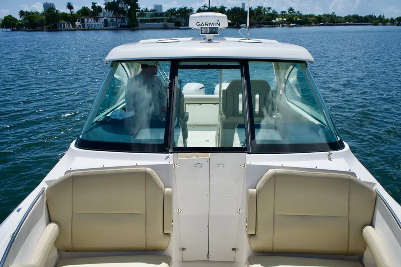 Slide: The Image of 2017 Pursuit DC 325 Dual Console boat on water, featuring beige seating and Garmin equipment. - 13