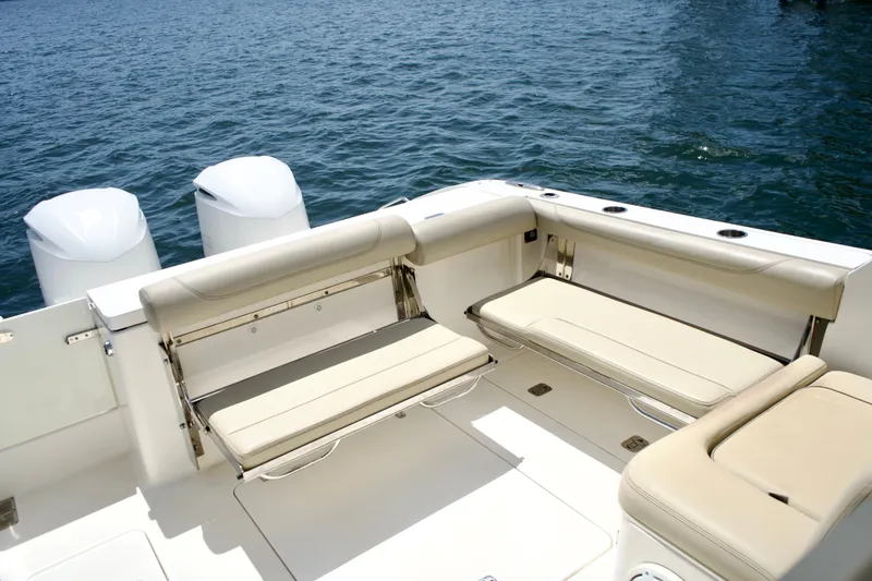 Slide: The Image of 2017 Pursuit DC 325 Dual Console boat interior with beige seating and twin engines. - 20