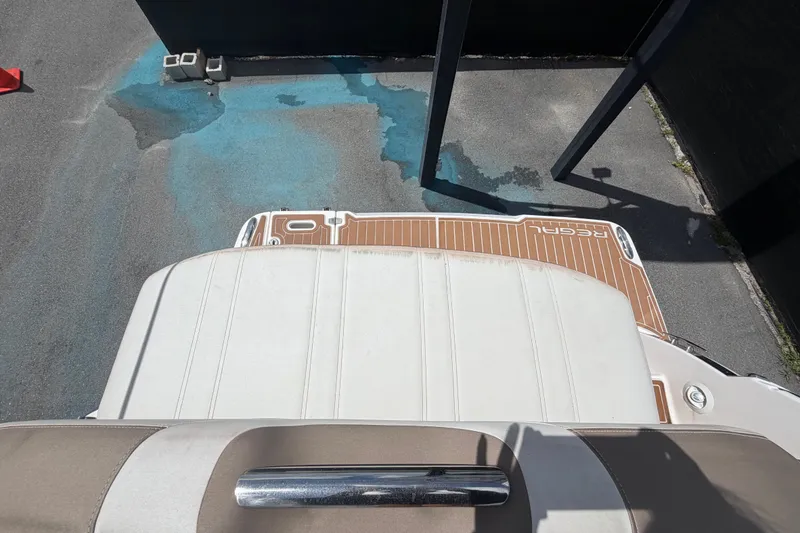 Slide: The Image of 2018 Regal 28 Express boat interior with white and tan seating, docked on a sunny day. - 103