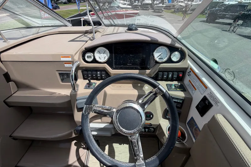 Slide: The Image of Cockpit of 2018 Regal 28 Express boat with steering wheel and control panel. - 34