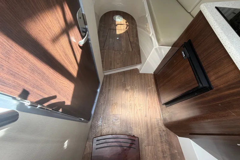 Slide: The Image of Interior of 2018 Regal 28 Express boat with wood flooring and compact kitchenette. - 56