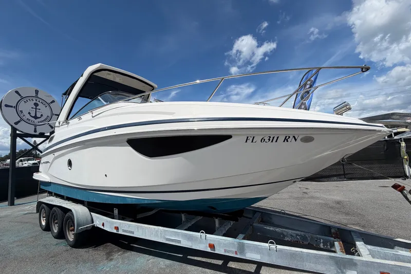 The Image of 2018 Regal 28 Express boat on trailer under clear blue sky. - 0