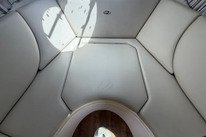 Slide: The Image of Interior seating area of a 2018 Regal 28 Express boat, featuring light upholstery. - 75