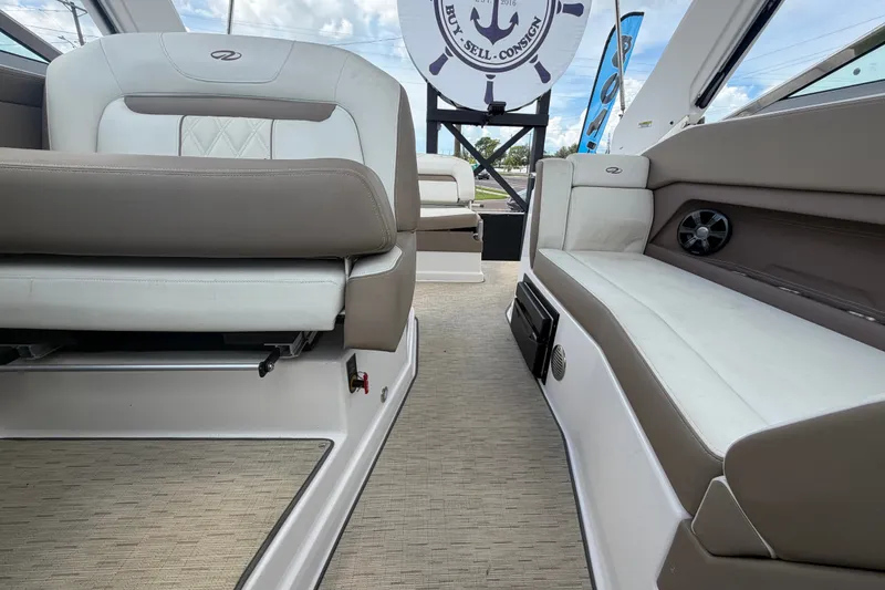 Slide: The Image of Interior of a 2018 Regal 28 Express boat, featuring beige and white seating. - 97