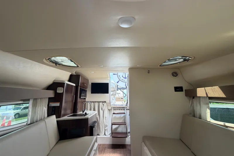Slide: The Image of Interior of 2018 Regal 28 Express boat with seating, kitchenette, and windows. - 81