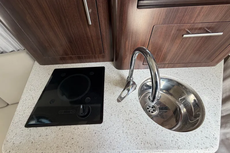 Slide: The Image of Compact kitchen area in 2018 Regal 28 Express boat with sink and stovetop. - 69