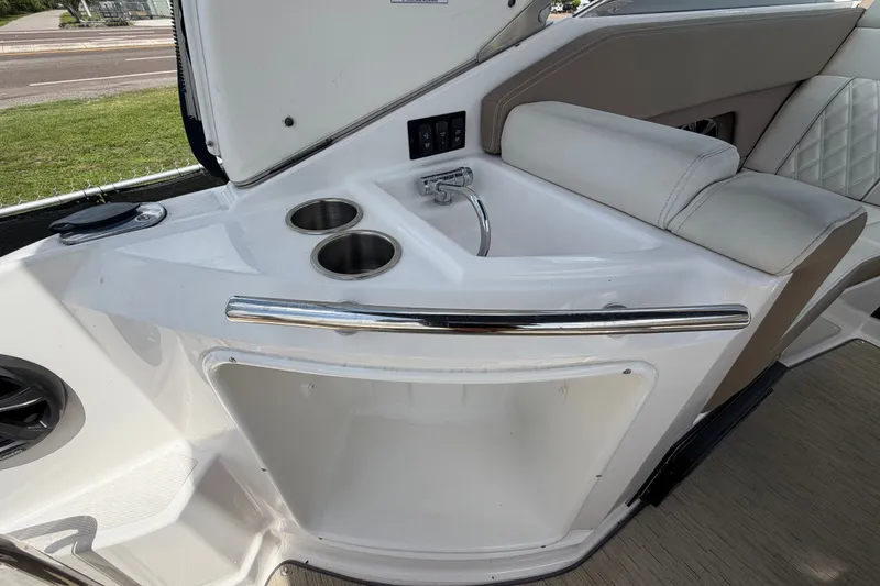 Slide: The Image of 2018 Regal 28 Express boat interior with sink and cup holders. - 19