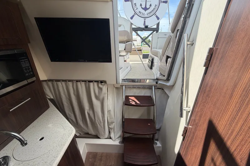Slide: The Image of Interior of 2018 Regal 28 Express boat with TV, microwave, and stairs to deck. - 85