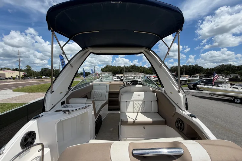 Slide: The Image of 2018 Regal 28 Express boat interior with seating, canopy, and clear sky background. - 14