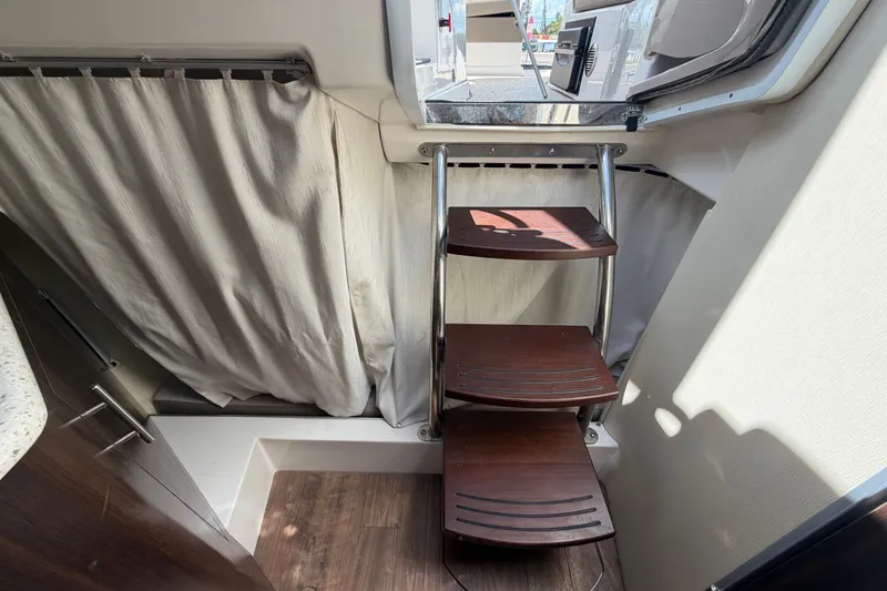 Slide: The Image of Interior of 2018 Regal 28 Express boat with wooden steps and curtain. - 91