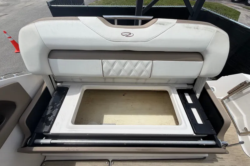 Slide: The Image of 2018 Regal 28 Express boat seat storage compartment open, showcasing interior space. - 101