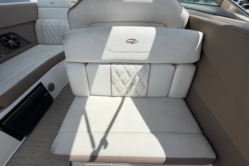 Slide: The Image of 2018 Regal 28 Express boat interior with beige and white cushioned seating. - 22