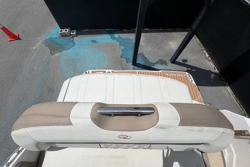 Slide: The Image of 2018 Regal 28 Express boat interior with cushioned seating and wooden deck. - 102