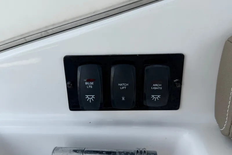 Slide: The Image of Control panel on a 2018 Regal 28 Express boat with switches for bilge, hatch, and arch lights. - 21