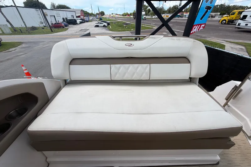Slide: The Image of 2018 Regal 28 Express boat seating area with white and beige upholstery. - 100