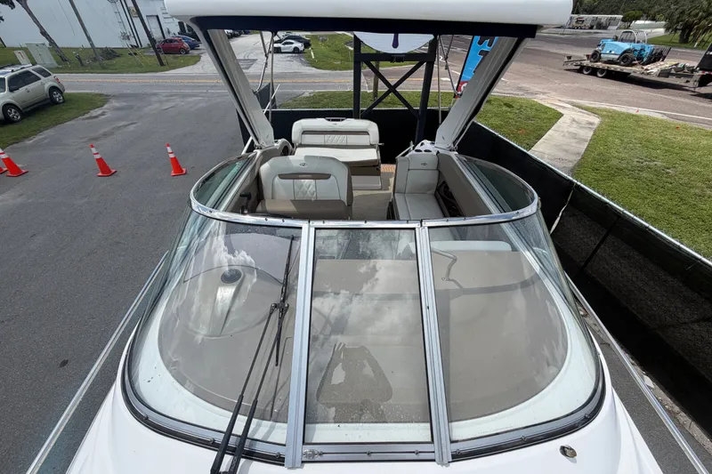 Slide: The Image of 2018 Regal 28 Express boat with open cockpit and seating, parked on pavement. - 52