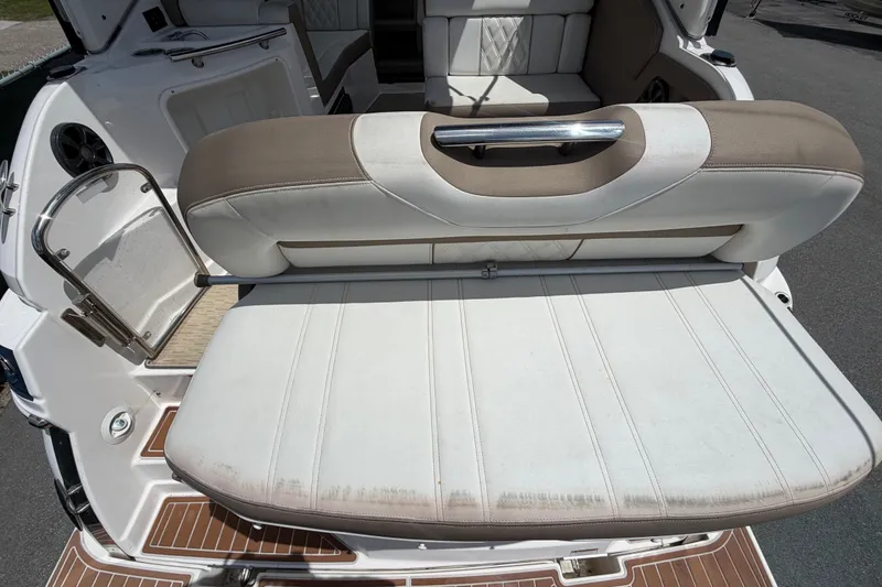 Slide: The Image of 2018 Regal 28 Express boat interior with beige and white seating, featuring a foldable backrest. - 15