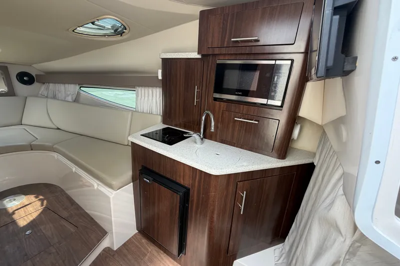 Slide: The Image of Interior of 2018 Regal 28 Express boat with kitchenette and seating area. - 58