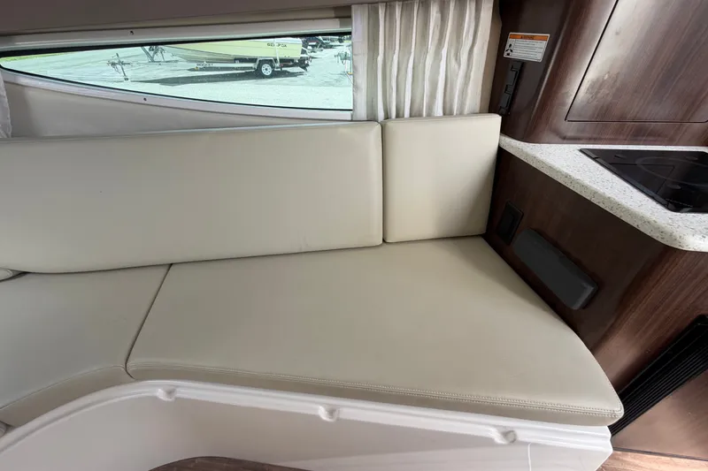 Slide: The Image of Interior of 2018 Regal 28 Express boat with beige seating and kitchenette. - 77