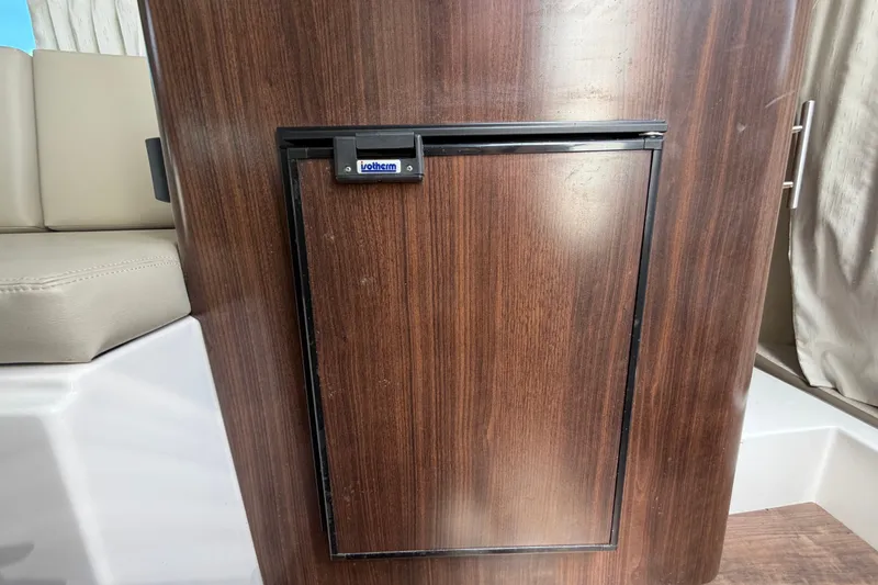 Slide: The Image of Wooden cabinet with a built-in Isotherm fridge on a 2018 Regal 28 Express boat. - 62