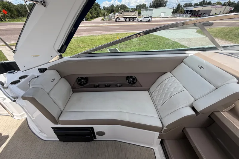 Slide: The Image of Interior seating of a 2018 Regal 28 Express boat, featuring plush white upholstery. - 28