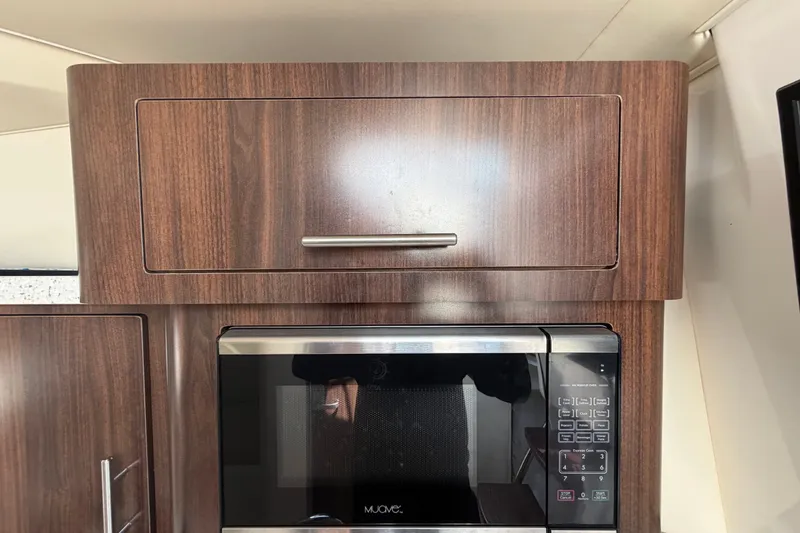 Slide: The Image of Wooden cabinet and microwave in 2018 Regal 28 Express boat interior. - 65