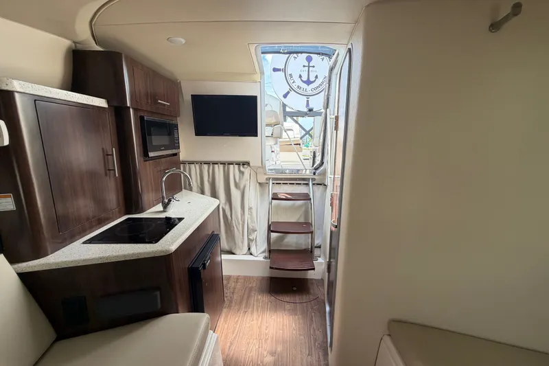 Slide: The Image of Interior of 2018 Regal 28 Express boat with kitchenette and seating area. - 82