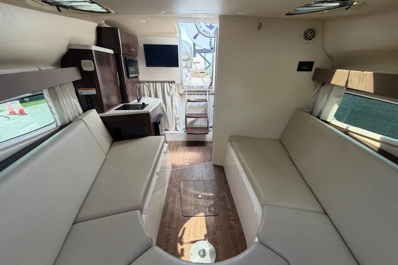 Slide: The Image of Interior of a 2018 Regal 28 Express boat with seating, kitchenette, and TV. - 80