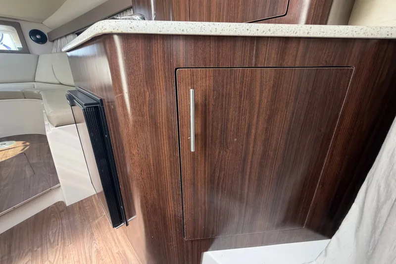 Slide: The Image of Interior of 2018 Regal 28 Express boat with wood cabinetry and seating area. - 60