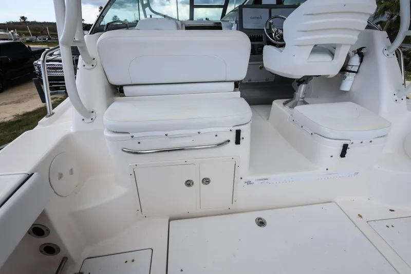 Slide: The Image of 2018 Robalo R305 Walkaround boat interior with white seating and storage compartments. - 16
