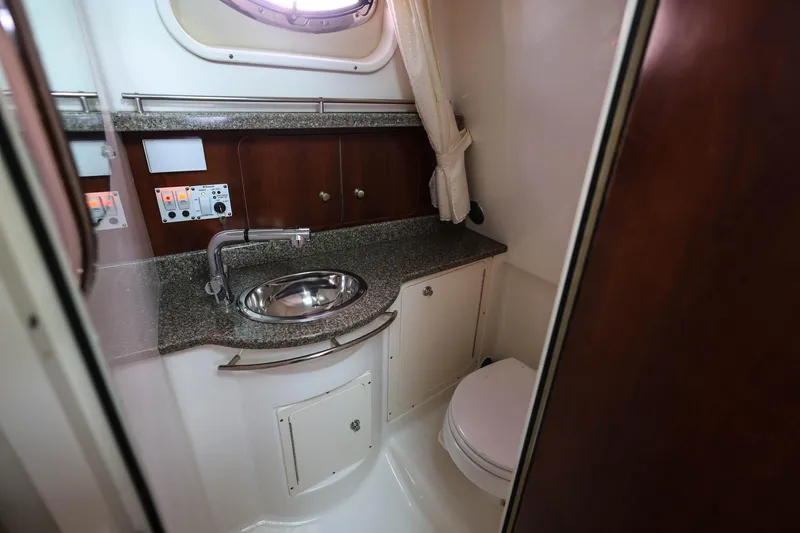 Slide: The Image of 2018 Robalo R305 Walkaround boat bathroom with sink, toilet, and control panel. - 28