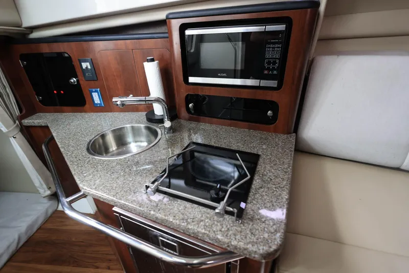 Slide: The Image of 2018 Robalo R305 Walkaround interior kitchen with sink, stove, and microwave. - 31