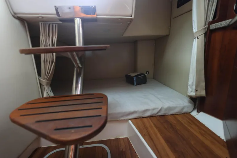 Slide: The Image of 2018 Robalo R305 Walkaround cabin interior with wooden steps and cushioned seating area. - 33