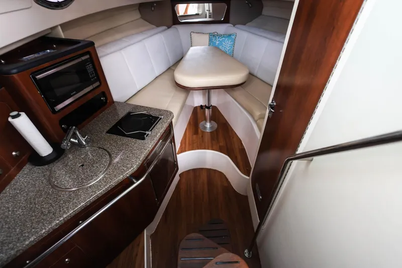 Slide: The Image of 2018 Robalo R305 Walkaround cabin interior with kitchenette and seating area. - 25