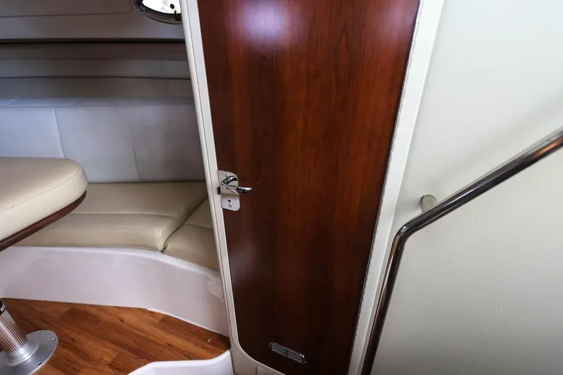 Slide: The Image of 2018 Robalo R305 Walkaround cabin interior with wooden door and beige seating. - 27