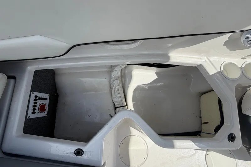 Slide: The Image of Interior view of a 2018 Scarab 195 G boat, featuring storage compartment and control panel. - 55