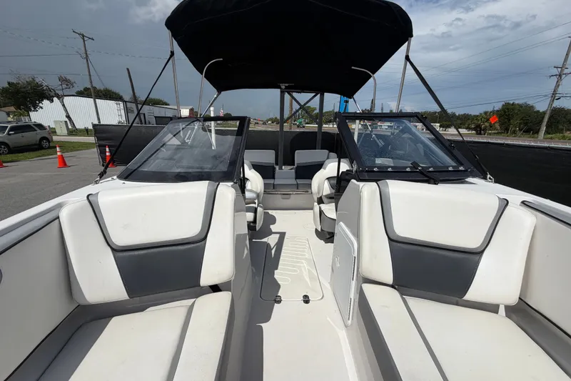 Slide: The Image of 2018 Scarab 195 G boat interior with white and gray seating, under a black canopy. - 44