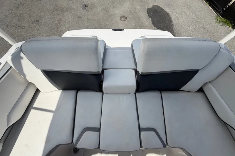 Slide: The Image of Rear seating area of a 2018 Scarab 195 G boat, featuring white and gray upholstery. - 57